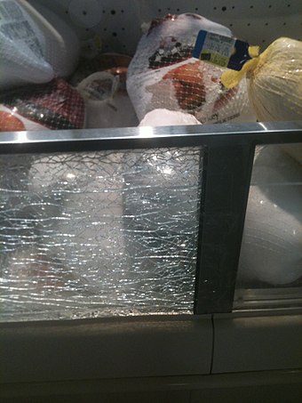 Tempered safety glass which has been laminated often does not fall out of its frame when it breaks – usually because an anti-splinter film has been applied on the glass, as seen in this grocery store meat case.