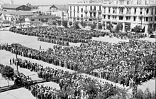 Photograph from above of thousands of people standing in a public square