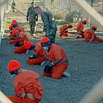 معتقلون يلبسون الزي البرتقالي عند وصولهم إلى القاعدة العسكرية في يناير 2002