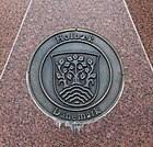 Coat of arms at twin town Celle (Germany), granite artwork below signpost