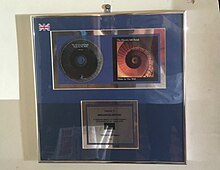 A silver disc for Holes in the Wall (denoting sales of over 60,000 copies) on display in Broughton Gifford, Wiltshire Electric Soft Parade silver disc, Broughton Gifford.jpg