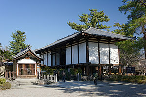 Wooden building with white walls on poles.