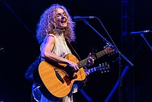 Griffin playing an acoustic guitar and singing