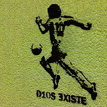 A stencil graffiti of Maradona running with the ball and the caption D10S ∃XISTE.
