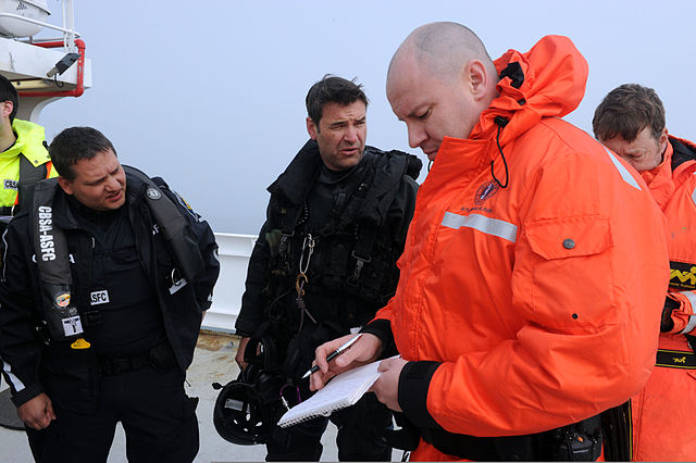 CBSA and RCMP members share information on the survey research vessel Strait Hunter, simulating a migrant vessel, during Frontier Sentinel (2012)