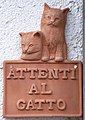Auf diesem Schild steht „Attenti al gatto“, das bedeutet: Vorsicht Katze!