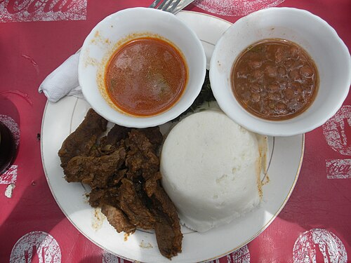 Posho or ugali consists of maize flour (cornmeal) cooked with water to a porridge- or dough-like consistency. Pictured on the bottom right of the plate, it is served with beef and sauce.
