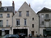 Photographie en couleurs de la façade d'un bâtiment montrant des vestiges de baies en plein cintre.