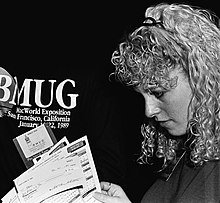 BMUG staffer Alisa Shulman surveys disk order forms in the BMUG booth at MacWorld Expo San Francisco, January 1989. Alisa Schulman 1989.jpg