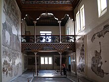 Salle d’Althiburos, ancienne salle de musique du palais avec une tribune et des mozaikler sur les murs et le sol.