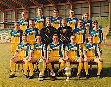 The Barry squad of 1999 at Jenner Park, with the League of Wales Cup, FAW Premier Cup and Cymru Premier trophies.