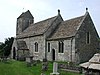 A stone church seen from the southeast, showing the chancel, beyond which is a nave with a higher roof and a porch and, beyond that, a tower with a saddleback roof