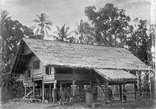 The frontal side of a Rumoh Aceh, the main entrance stairways is visible, leading to a roofed front terrace. COLLECTIE TROPENMUSEUM Paalwoning Atjeh TMnr 60008462.jpg