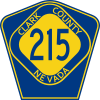 A blue pentagon with a yellow diamond inside. The text "215" is in blue inside the diamond, and the text "CLARK COUNTY NEVADA" is in yellow surrounding the diamond.