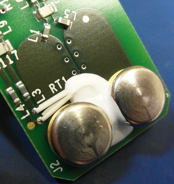 Reference junction block inside a Fluke CNX t3000 temperature meter. Two white wires connect to a thermistor (embedded in white thermal compound) to m