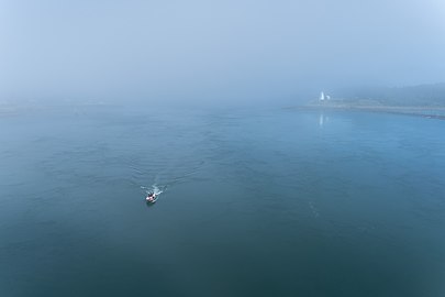 Fishing boat in the fog with the Mulholland Point Lighthouse in the background, Brunswick, Canada