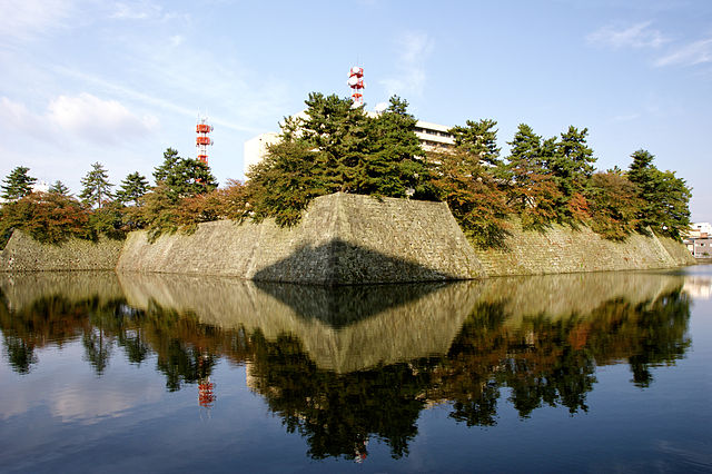 The surviving moat and lower walls of the castle, with the Fukui prefectural office present on the site of the castle keep