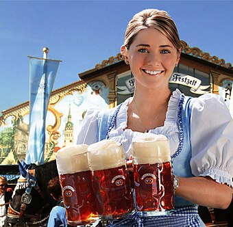 A waitress with Hacker-Pschorr, one of the traditional beers allowed to be served at Oktoberfest. She wears a Dirndl, a traditional women's dress of Bavaria.