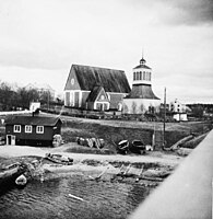 Vy från Kalix första bro mot Kalix kyrka år 1941. Till vänster fanns en slags allmän badstuga och även en bastu där kalixborna kunde bada. Här fanns även en kaj.