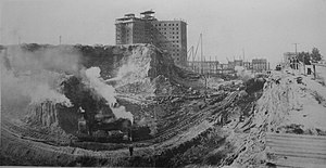 A regrade in progress circa 1907. The building under construction is the New Washington Hotel, now the Josephinium at the corner of Second and Stewart. Leveling the Hills of Seattle.jpg