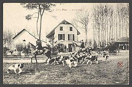 Fotografia em preto e branco de cavaleiros em seus cavalos e cães de caça.