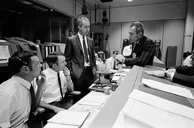 Discussion in the Mission Operations Control Room during the Apollo 13 mission between Lunney (center) and astronauts James McDivitt and Deke Slayton