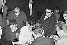 Petrosian (standing on right, with jacket) at the 1961 European Chess Team Championship. Seated, facing right, is Mikhail Tal, then world champion. Tal Petrojan Oberhausen 1961 high-quality.jpg