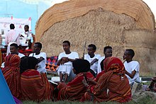 Somali men and women in front of a traditional house University students sits in front of Somali traditional house.jpg