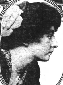 A young white woman with dark hair in a bouffant updo, photographed in profile