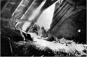 A soldier on a bed of hay, writing by the light from a hole in the roof