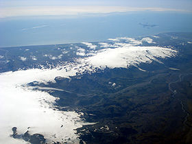Vue aérienne de l'Eyjafjöll couronné par l'Eyjafjallajökull (à droite) avec le Mýrdalsjökull (à gauche) et les îles Vestmann (en haut à droite).
