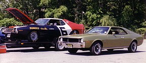 Shows two cars: Sunoco racing AMC Javelin on an open car hauling trailer and a 1970 Javelin SST finished in light green