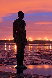 Another Place (1997) where 100 cast-iron figures face out to sea on Crosby Beach, near Liverpool Antony Gormley - Another Place - Crosby Beach 01.jpg