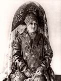 Femeie ce poartă un cocoșnic dublu, bogat ornamentat. Fotografie din secolul al XX-lea.