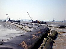Geotextile tubes being filled with sand. Geotextile tubes hyraulically filled with sand.jpg