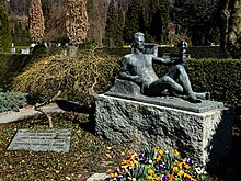 Çikolata makinelerinin mucidi olan girişimci John Heinrich Volkmann-Rogge (1855–1928) bunları New York'ta Stollwerck için üretiyor.  Aile mezar alanı 4, Lucerne Şehri, Friedental mezarlığında.  Schibler tarafından heykel.  Aile mezar alanı 4, Friedental mezarlığında, Lucerne, İsviçre kasabası