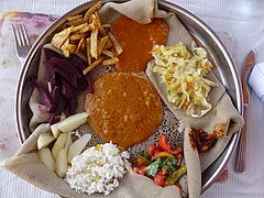 Misir WotMisir Wot is a Lentil stew, served with a variety of vegetables, there are several variations. This example is served potatoes, beets, apple, salad, paprika and rice atop of injera. A popular vegan dish.