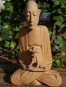 Monk meditating and holding a flower