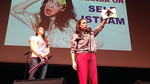 Magic trick: Miranda sings while being stabbed through the neck to boost her "self isteam", as noted on the projection behind her, 2014. MirandaSanDiego.jpg