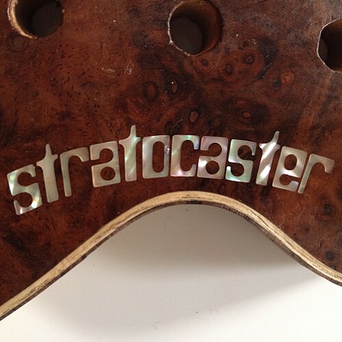 Mother of pearl inlay into walnut burl on a customised Fender Stratocaster.
