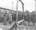An Austrian-Jewish survivor points out the gallows to General Dwight D. Eisenhower.