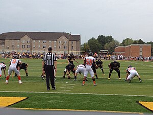 View of college football play from defensive side