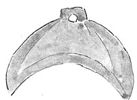 A greenstone crescent shaped pendant which has been sharpened at the inner curve.