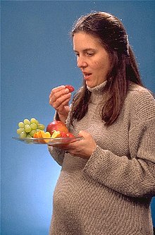 אישה בהריון אוכלת פירות טריים כחלק משמירה על תזונה טובה