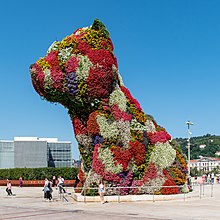 Puppy by Jeff Koons (2010) is a self-aware display of kitsch, specifically as a combination of opulence and cuteness. Puppy de Jeff Koons (2) -- 2021 -- Bilbao, Espana.jpg