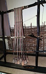Reconstruction of a vertical neolithic loom with genuine loom weights and string heddles, on display at the National Museum of Textile Industry in Sliven, Bulgaria