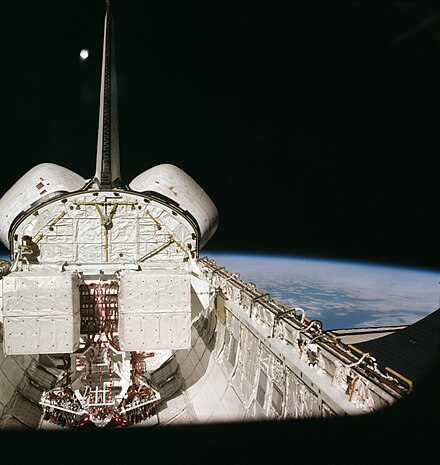 STS-1 photo showing missing thermal tiles on OMS pods to the left and right of the vertical tail fin