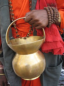 Pot en métal avec une hanse tenu par une main masculine