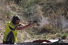 An Australian competitor firing his handgun from a seated position during the 2013 IPSC Australasia Handgun Championship. Standard competitor at the 2013 IPSC Australasian Handgun Championship.jpg