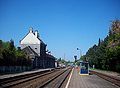 Zicht op de perrons + stationsgebouw in de oudere situatie